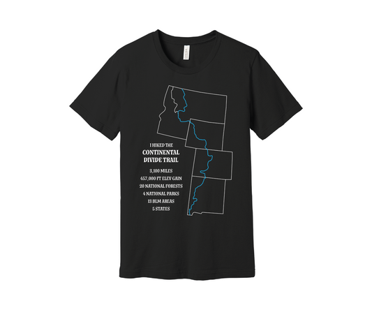 A black T-shirt displays a white outline of Arizona, Colorado, Montana, Wyoming and Idaho with the route of the Continental Divide Trail marked by a blue line. Text reads, "I hiked the Continental Divide Trail - 3,100 miles, 457,000 ft of elevation gain, 30 national forests, 4 national parks, 13 BLM areas, 5 states.