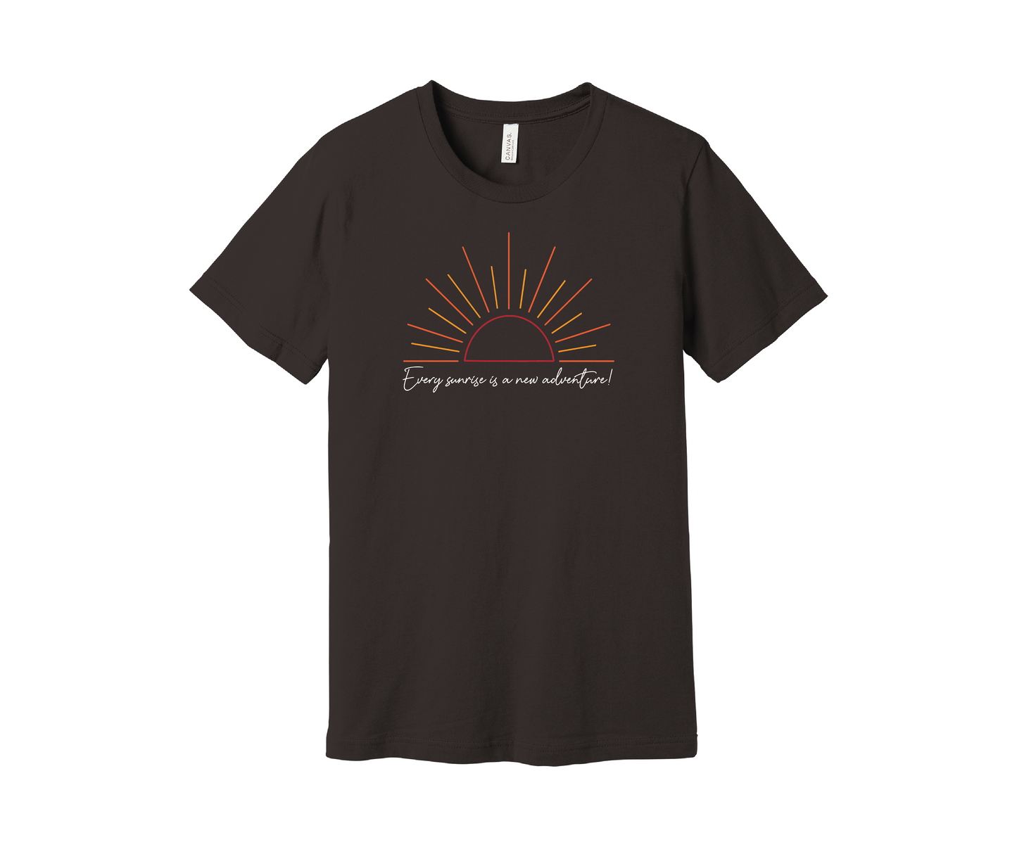 A brown T-shirt features a graphic of a stylized orange and yellow sunrise above a handwritten cursive message in white that reads, "Every sunrise is a new adventure!" The shirt has a simple and modern design.