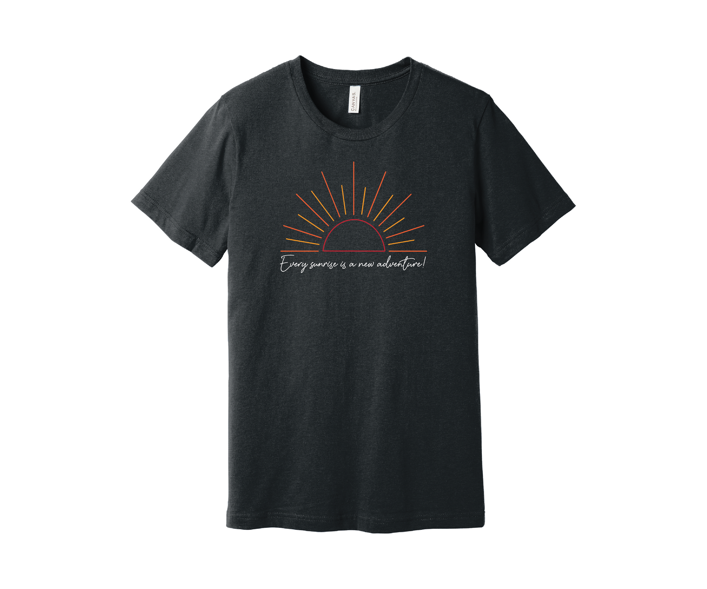 A dark gray heather T-shirt features a graphic of a stylized orange and yellow sunrise above a handwritten cursive message in white that reads, "Every sunrise is a new adventure!" The shirt has a simple and modern design.