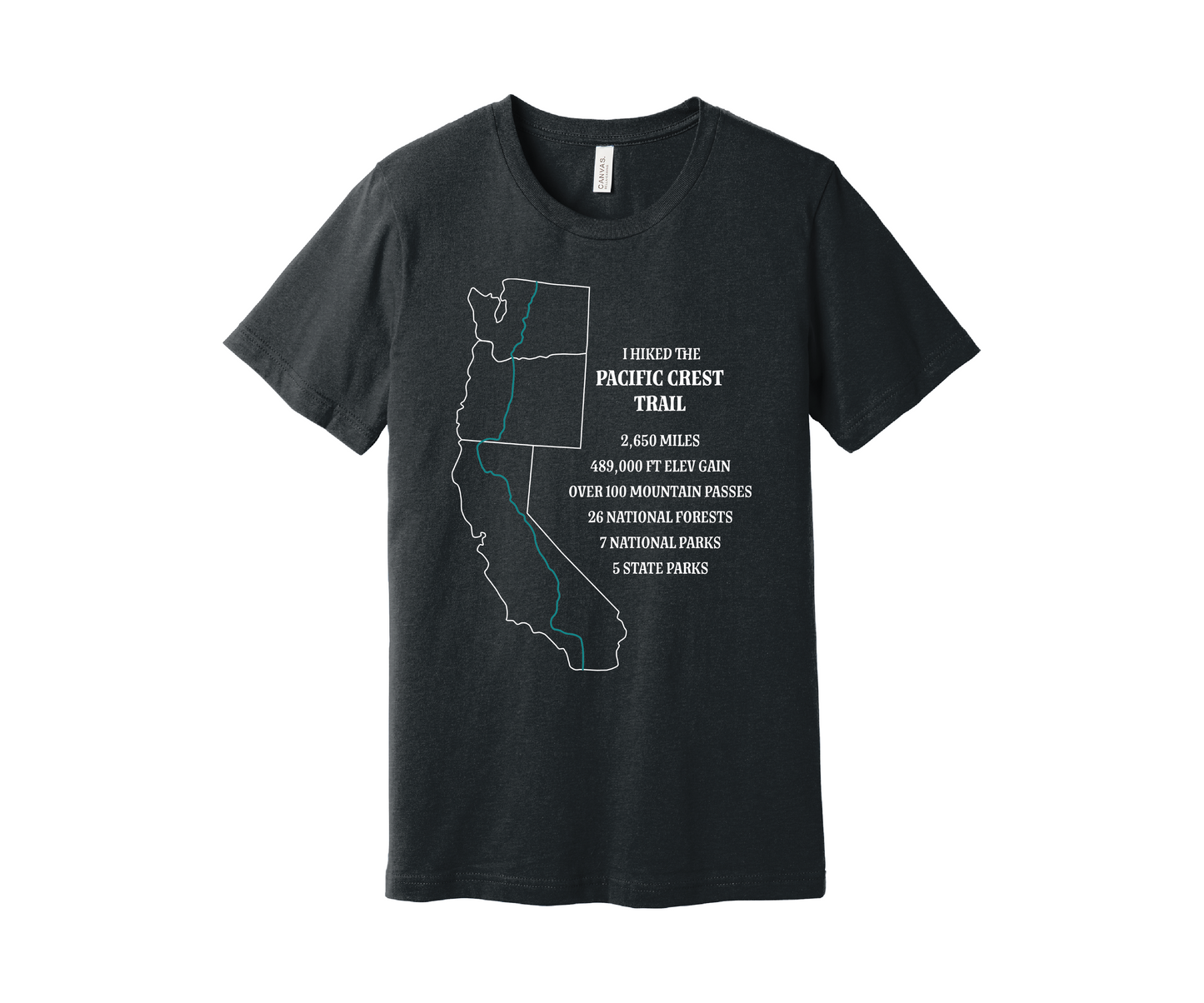 A dark gray heather T-shirt displays a white map outline of the states of California, Oregon and Washington and the route of the Pacific Crest Trail in teal. Text on the shirt reads: "I Hiked the Pacific Crest Trail," and lists details: 2,650 miles, 489,500 ft elevation gain, Over 60 Mountain Passes, 28 National Forests, 7 National Parks, 5 State Parks.