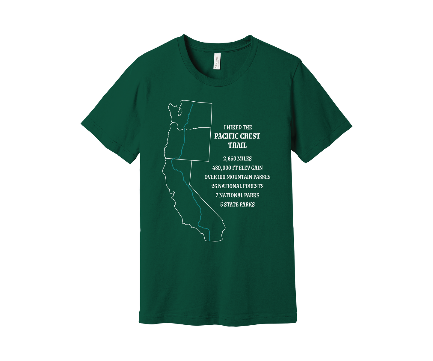 An evergreen-colored T-shirt displays a white map outline of the states of California, Oregon and Washington and the route of the Pacific Crest Trail in teal. Text on the shirt reads: "I Hiked the Pacific Crest Trail," and lists details: 2,650 miles, 489,500 ft elevation gain, Over 60 Mountain Passes, 28 National Forests, 7 National Parks, 5 State Parks.