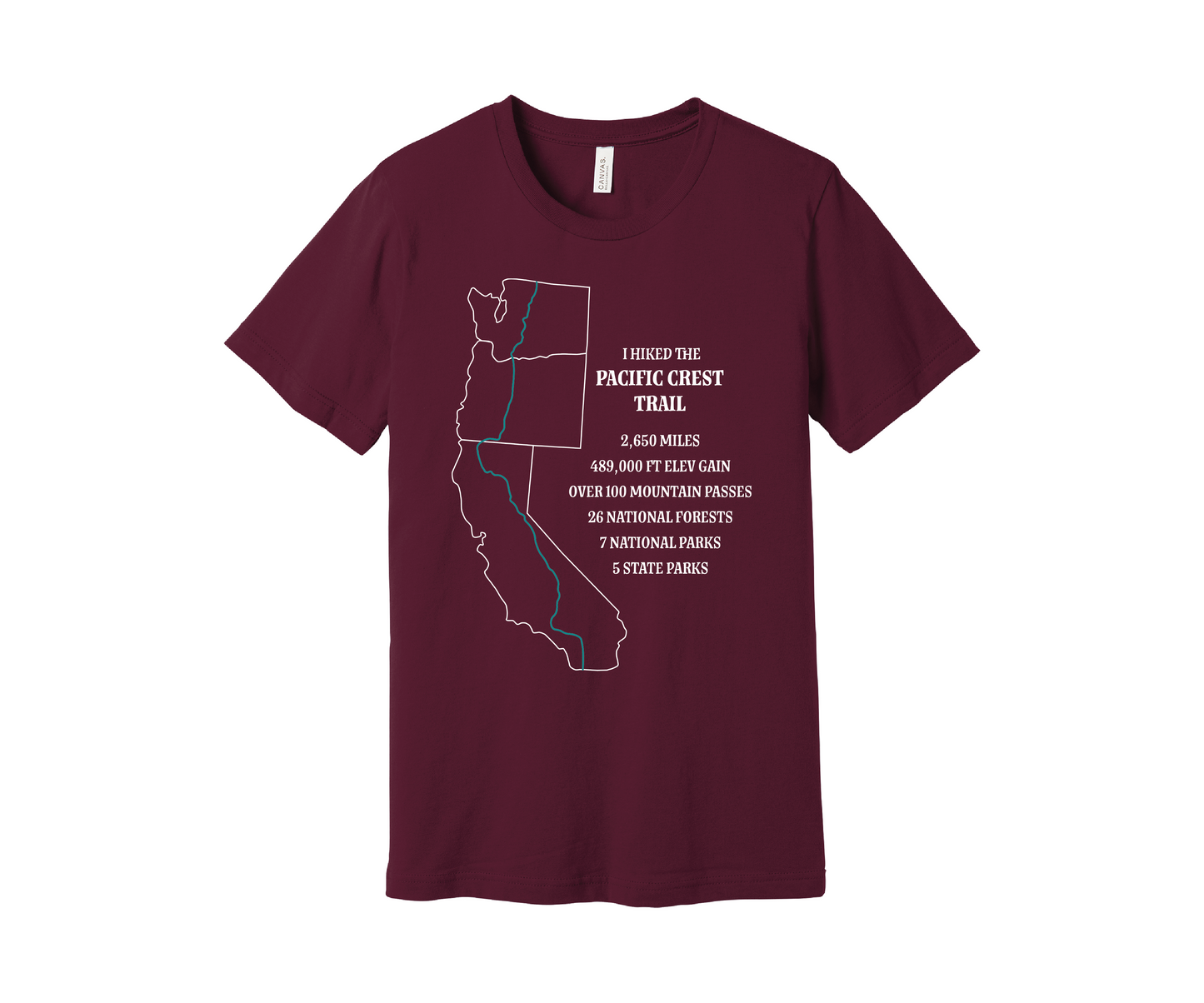 A maroon T-shirt displays a white map outline of the states of California, Oregon and Washington and the route of the Pacific Crest Trail in teal. Text on the shirt reads: "I Hiked the Pacific Crest Trail," and lists details: 2,650 miles, 489,500 ft elevation gain, Over 60 Mountain Passes, 28 National Forests, 7 National Parks, 5 State Parks.