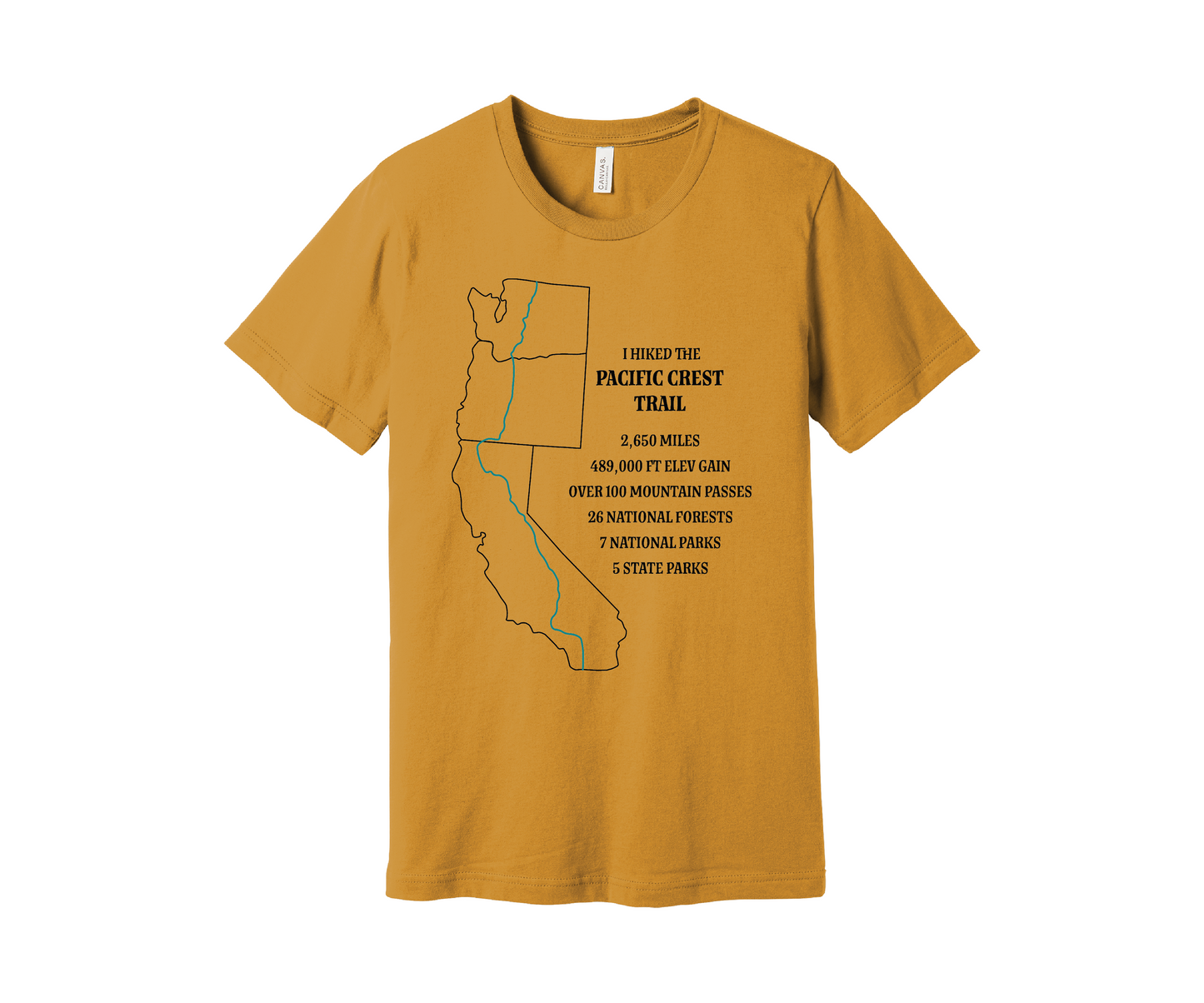 A dusky yellow T-shirt displays a black map outline of the states of California, Oregon and Washington and the route of the Pacific Crest Trail in teal. Text on the shirt reads: "I Hiked the Pacific Crest Trail," and lists details: 2,650 miles, 489,500 ft elevation gain, Over 60 Mountain Passes, 28 National Forests, 7 National Parks, 5 State Parks.