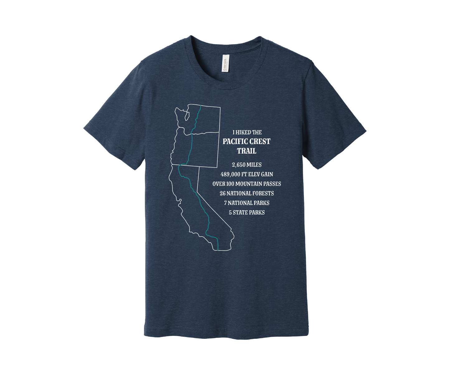 A navy heather T-shirt displays a white map outline of the states of California, Oregon and Washington and the route of the Pacific Crest Trail in teal. Text on the shirt reads: "I Hiked the Pacific Crest Trail," and lists details: 2,650 miles, 489,500 ft elevation gain, Over 60 Mountain Passes, 28 National Forests, 7 National Parks, 5 State Parks.